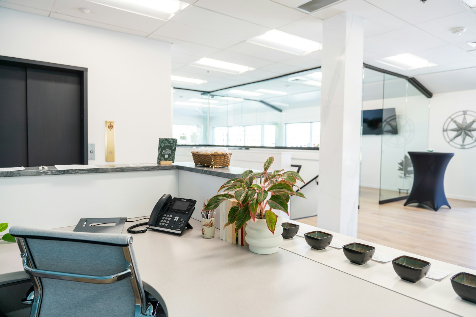 Illustrative commercial reception with bright finishes and glass offices